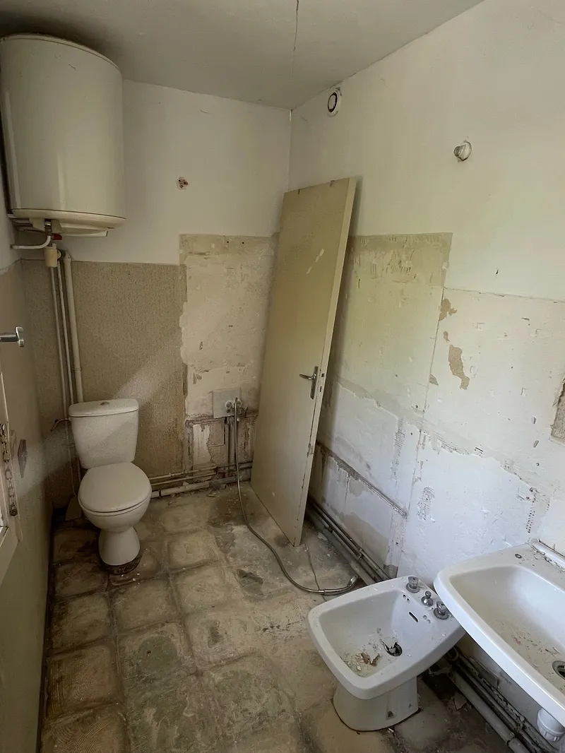 Avant : salle d’eau vétuste, murs décrépis et sanitaires déposés