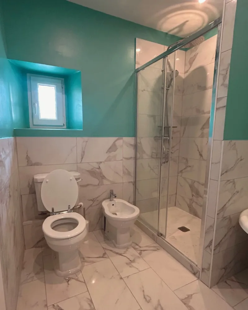 Salle de bain rénovée à Montauban : carrelage effet marbre et douche vitrée