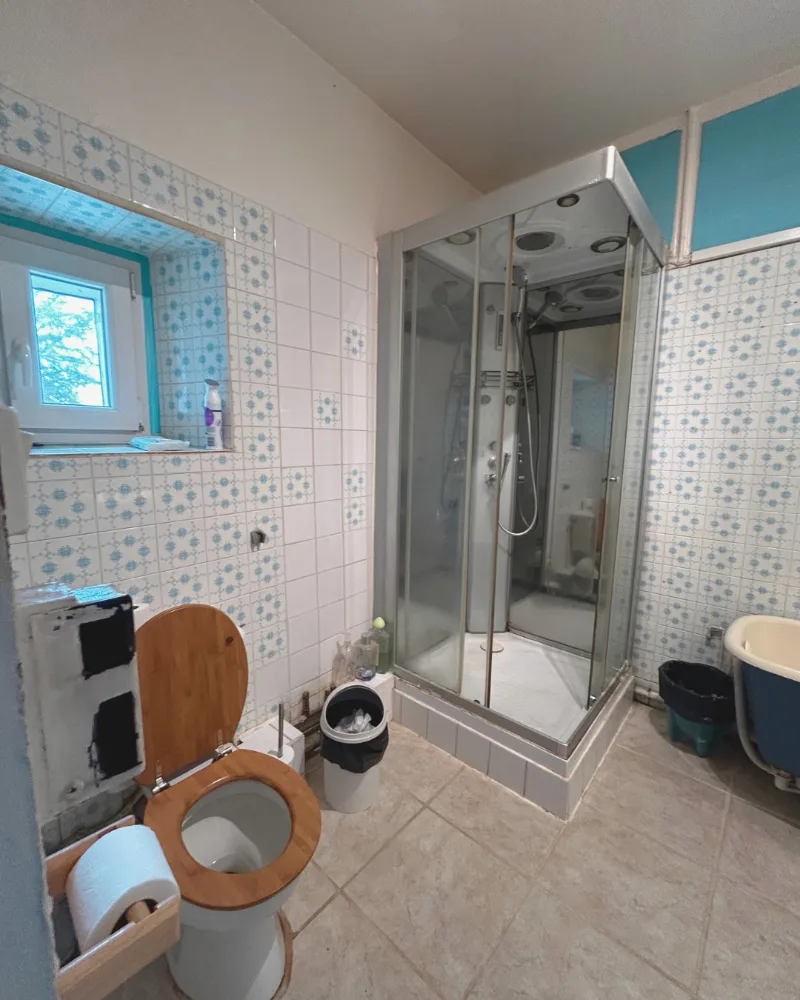 Avant travaux : cabine de douche vétuste et faïence à motifs dans une salle de bain de Montauban